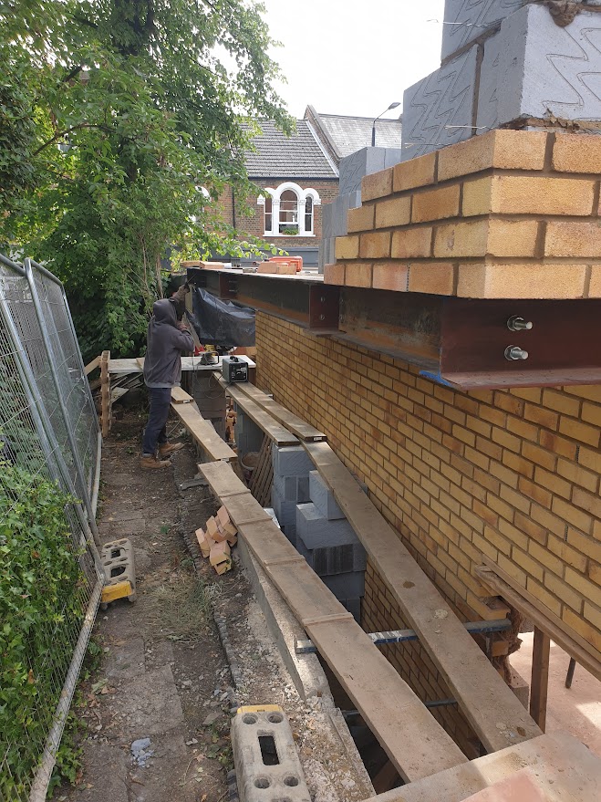 Overhang steel structure installed to support the brickwork above the alleyway in a new build project in West Hampstead by Optima Builders