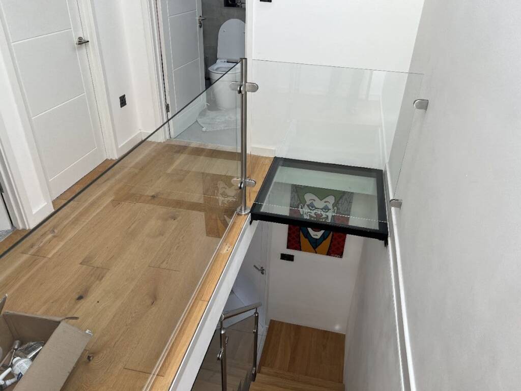 Glass balustrade installation with a small glass floor section for a desk area in a new build project in West Hampstead by Optima Builders