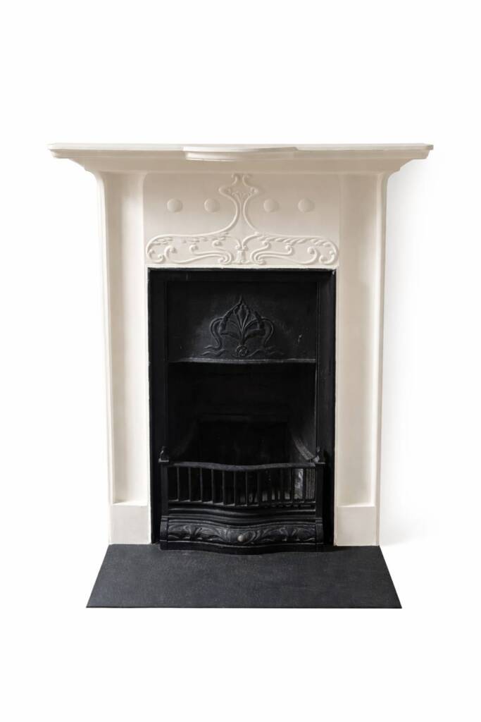 Victorian cast iron fireplace with decorative cream mantel and black hearth