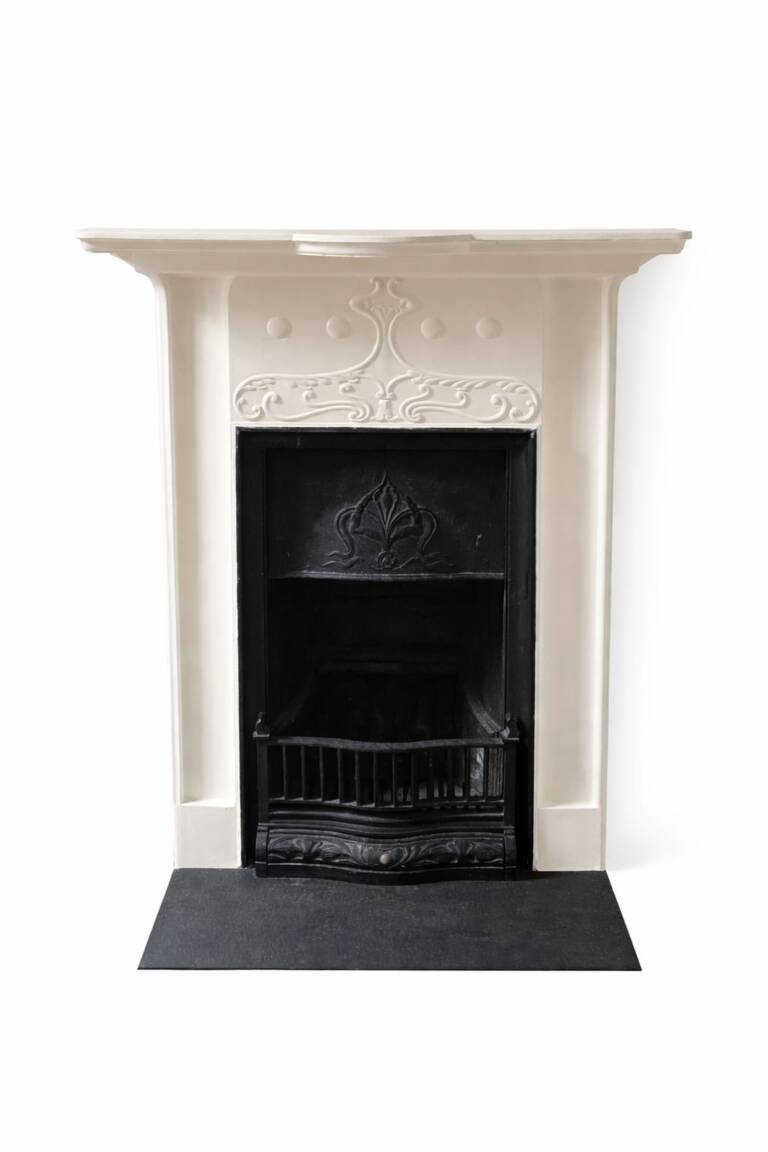 Victorian cast iron fireplace with decorative cream mantel and black hearth