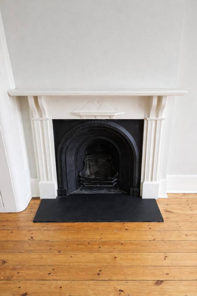 Victorian cast iron fireplace with cream mantel surround and black slate hearth – period feature fireplace for UK Victorian homes.